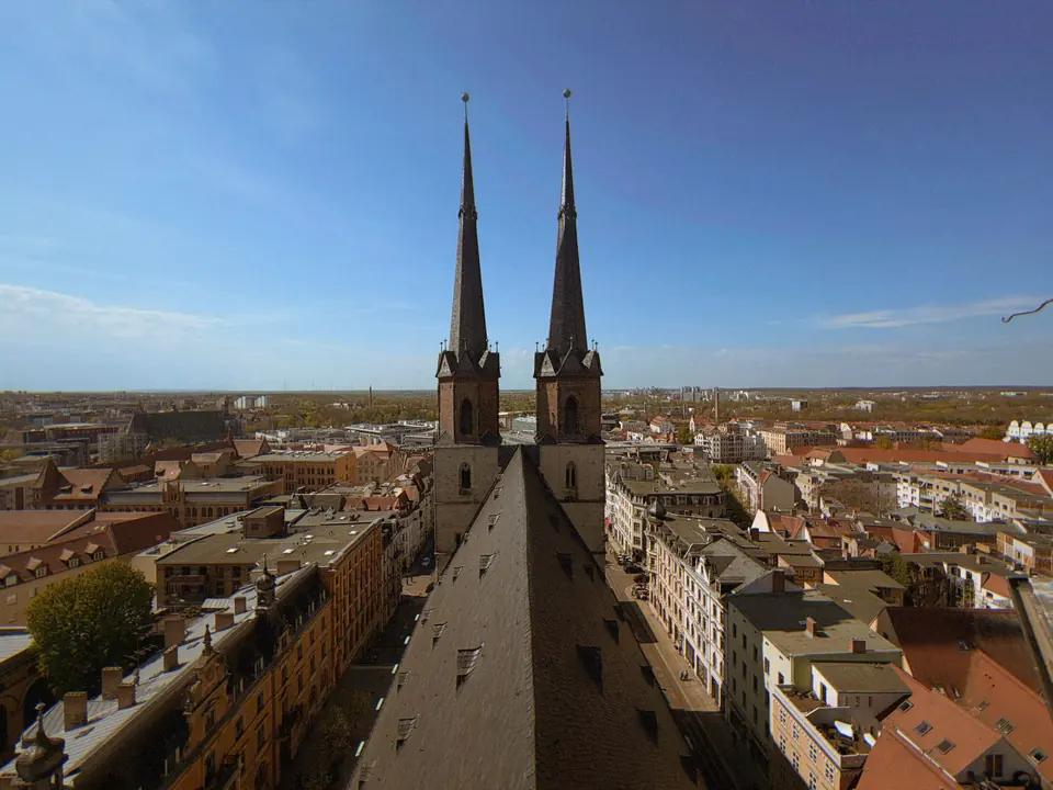 Luftaufnahme von Halle (Saale), Deutschland, die die ikonische Marktkirche und das Stadtbild unter einem klaren blauen Himmel zeigt.