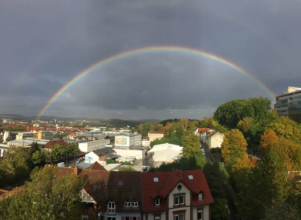 Ein doppelter Regenbogen spannt sich über Kaiserslautern, Deutschland, und zeigt die lebendige Natur nach dem Regen.