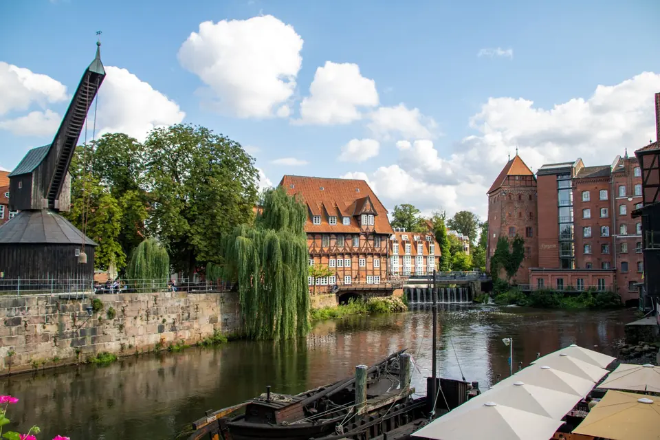 Charmante Aussicht auf die historischen Gebäude und den Wasserweg von Lüneburg unter einem blauen Himmel.